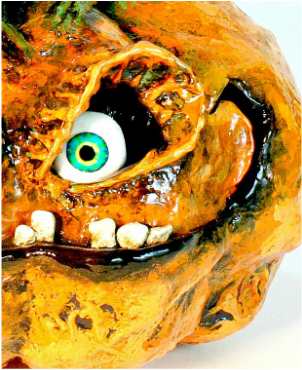 Artist Jessica Dvergsten paper mache orange jack o lantern Halloween decorations with green eyes